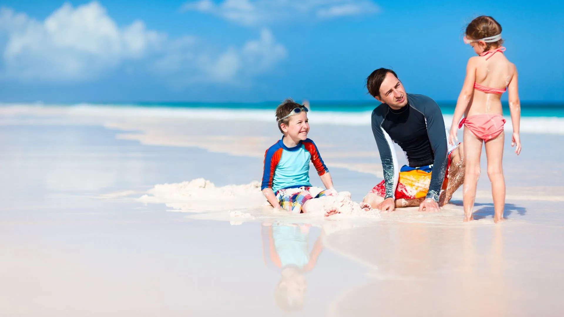 dad and kids on the beach after using whitening toothpaste with Invisalign