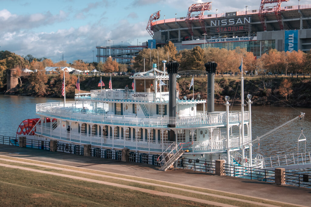 A white and blue paddleboat with four decks.